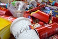 Big pile of many disposable colored trash from edible products of famous food and beverage manufacturers. Soda cans and chocolate