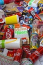 Big pile of many disposable colored trash from edible products of famous food and beverage manufacturers. Soda cans and chocolate