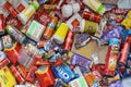 Big pile of many disposable colored trash from edible products of famous food and beverage manufacturers. Soda cans and chocolate