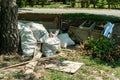 Big pile or stack of garbage and junk dumped on the grass near street polluting the city with smell and litter