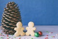 Big pine cone, gingerbread men and gifts on blue background. Happy New Year and Merry Christmas concept. Copy space Royalty Free Stock Photo
