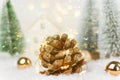 Big pine cone with golden garland lights in winter scene in forest with fir trees falling snow. Christmas New Years holiday magic Royalty Free Stock Photo