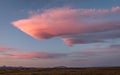 Big pink cloud in a sunset sky over a beautiful field with mountains in the background in Iceland Royalty Free Stock Photo