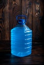 Big plastic blue bottle on a dark wood background Royalty Free Stock Photo