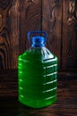 Big plastic green bottle on a dark wood background Royalty Free Stock Photo