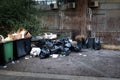 Big plastic dumpsters garbage can full of overflow litter polluting the street in the city with bags of food bottles cardboard Royalty Free Stock Photo
