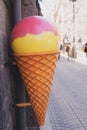 Big plastic ice cream cone sign of cafe or candy shop on city urban street - dessert and summer sweets concept Royalty Free Stock Photo