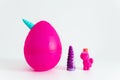 Big plastic pink unicorn egg and  toys inside with slime. White background. Popular plastic toy with surprise inside Royalty Free Stock Photo