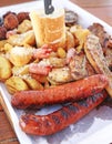 Big plate with delicious variety of meat - grilled steak, meatballs, chicken, sausages, bread and potato fries Royalty Free Stock Photo