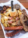 Big plate with delicious variety of meat - grilled steak, meatballs, chicken, sausages, bread and potato fries Royalty Free Stock Photo