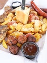 Big plate with delicious variety of meat - grilled steak, meatballs, chicken, sausages, bread and potato fries Royalty Free Stock Photo