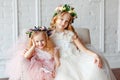 Big portrait of two cute funny and beauty little girl - sisters in wreaths of fresh flowers and lush pink elegant dresses laugh Royalty Free Stock Photo