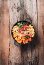 Big pot with sliced colorful vegetables and cooking utensils on rustic wooden background. Top view. Organic vegetarian ingredients Royalty Free Stock Photo