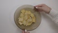 The big potato chips bowl. Hand of woman eating chips, close-up. Woman`s hands twist a plate of chips