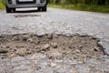 Car approaching huge potholes in asphalt road Royalty Free Stock Photo