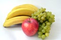 Big red apple in front of the bunch of bananas and ripe indian green grape isolated on white background. Royalty Free Stock Photo