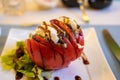 Big red french tomato served with fresh mozzarella cheese, basil pesto and creme balsamico as starter in restaurant in Provence, Royalty Free Stock Photo