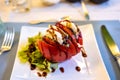 Big red french tomato served with fresh mozzarella cheese, basil pesto and creme balsamico as starter in restaurant in Provence, Royalty Free Stock Photo