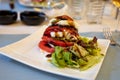 Big red french tomato served with fresh mozzarella cheese, basil pesto and creme balsamico as starter in restaurant in Provence, Royalty Free Stock Photo