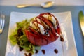 Big red french tomato served with fresh mozzarella cheese, basil pesto and creme balsamico as starter in restaurant in Provence, Royalty Free Stock Photo