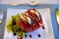 Big red french tomato served with fresh mozzarella cheese, basil pesto and creme balsamico as starter in restaurant in Provence, Royalty Free Stock Photo