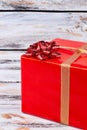Big red gift box, wooden background. Royalty Free Stock Photo