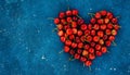 Big red heart made of ripe homegrown cherries on the blue concrete cosmos background. Summer june fruit harvest. Free copy space, Royalty Free Stock Photo