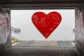 A big red heart is painted on a white wall. graffiti street art expressing love