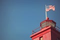 Red lighthouse with American Flag