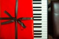 Big red present box on the piano. Christmas decoration of Interior. Happy birthday to you. Royalty Free Stock Photo