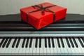 Big red present box on the piano. Christmas decoration of Interior. Happy birthday to you. Royalty Free Stock Photo