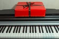 Big red present box on the piano. Christmas decoration of Interior. Happy birthday to you. Royalty Free Stock Photo
