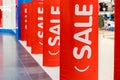 Big red sales poster on entrance clothing retailer.Discount sale label at shop entrance. Sale up to 50 percent.shopping