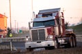 Big red semi truck turn on the highway ramp