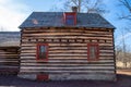 Big red windows in historical log cabin reflecting trees. Royalty Free Stock Photo