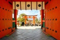 Big red wooden gates and Torii pole of Fushimi Inari Shrine with crowd of peoples and tourists