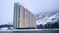 Big residential building near the ocean and mountains, in a northern country. Modern living in harsh climate. Generative AI