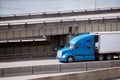 Big rig blue pro semi truck transporting reefer semi trailer on Royalty Free Stock Photo