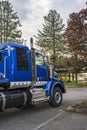 Big rig blue semi truck tractor with back compartment for truck driver rest standing on the parking lot in sunshine Royalty Free Stock Photo