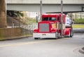 Big rig bright red classic American idol semi truck for long haul routs with high chrome exhaust pipes transporting semi trailer Royalty Free Stock Photo