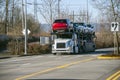 Big rig car hauler semi truck transporting cars on two levels semi trailer driving on divided road