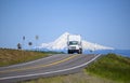 Big rig day cab semi truck with box trailer running on the road with snow mountain on the background Royalty Free Stock Photo