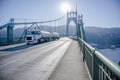 Big rig day cab white semi truck transporting liquid cargo in two tank semi trailers driving on the St Johns Bridge in Portland Royalty Free Stock Photo