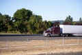 Big rig powerful semi truck with dry van trailer move ahead on s Royalty Free Stock Photo