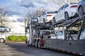 Big rig industrial car hauler with two level semi trailer with cars standing on the parking lot take a break Royalty Free Stock Photo