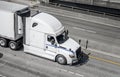 Big rig long haul semi truck transporting food in refrigerated semi trailer running on the wide highway road Royalty Free Stock Photo