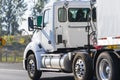 Big rig powerful day cab semi truck transporting cargo in dry van semi trailer running on the local road Royalty Free Stock Photo