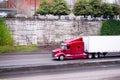 Big rig red semi truck with dry van semi trailer going down on h Royalty Free Stock Photo