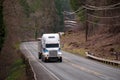 Big rig semi truck with bulk semi trailer moving by winding road Royalty Free Stock Photo