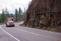 Big rig semi truck with day cab transporting cargo on flat bed s